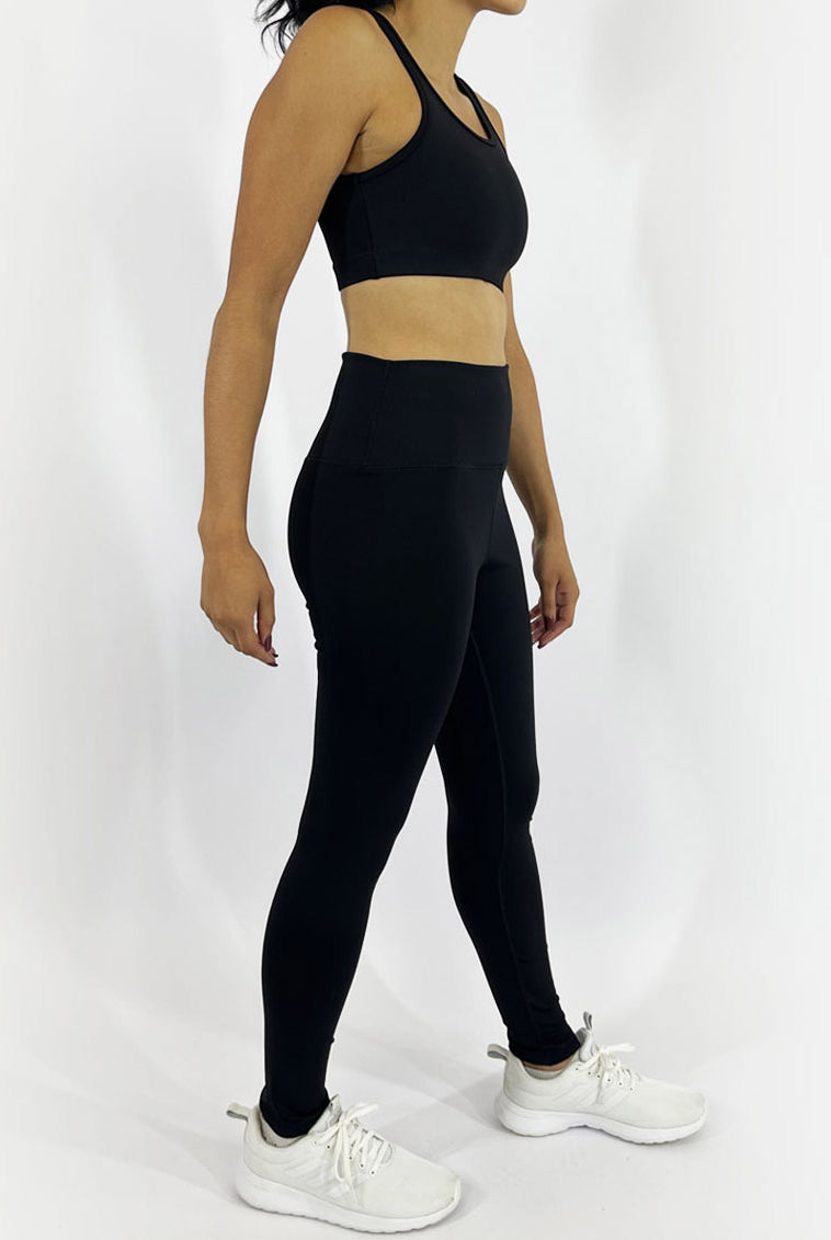 A woman side view wearing custom fit solid black leggings