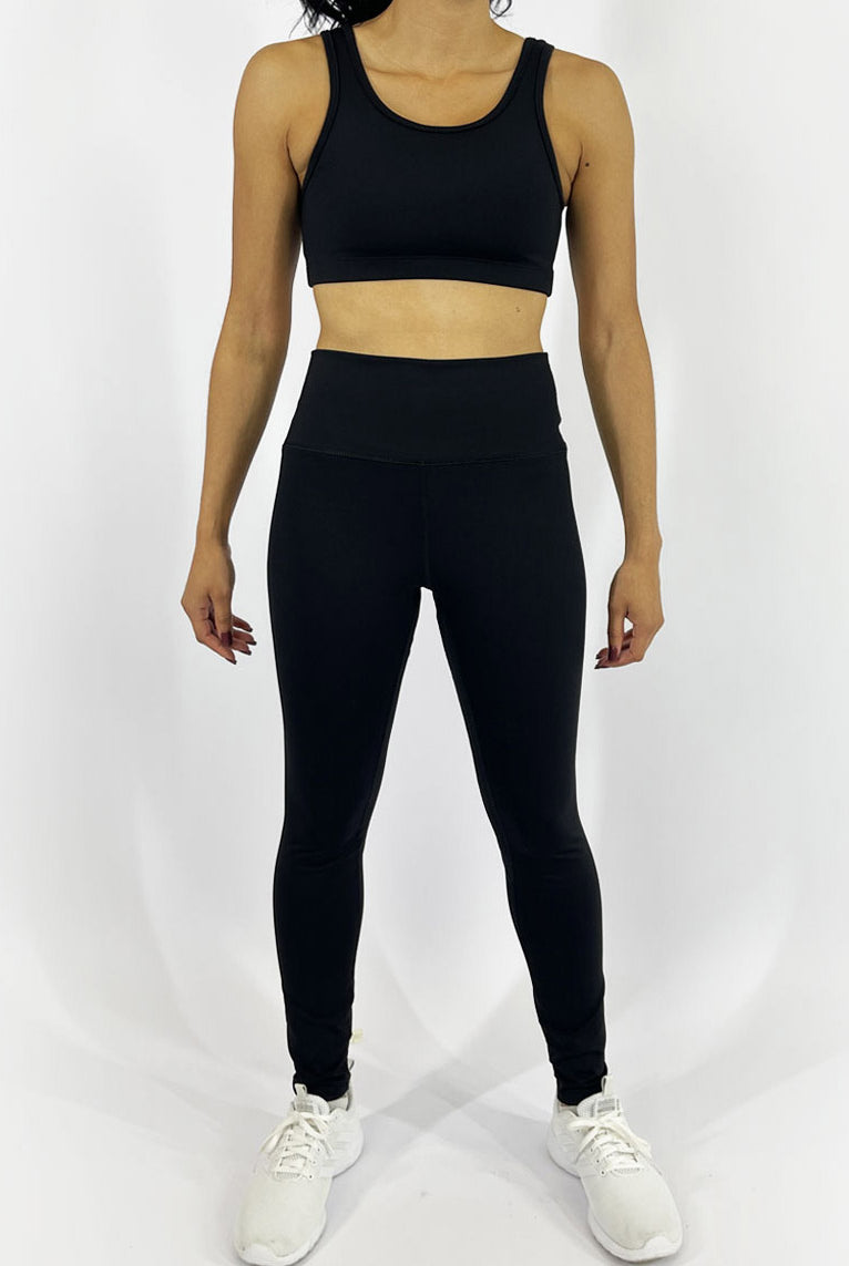A woman wearing custom fit solid black leggings